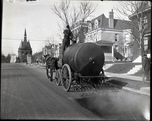 Street oiling truck at work on Washington Place near the entrance from Union Boulevard